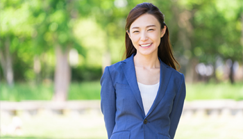 緑の中で微笑む女性の写真